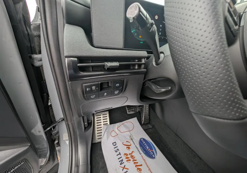 Vue rapprochée côté gauche du poste de conduite du Hyundai Tucson gris, avec pédalier aluminium et commandes sous tableau de bord.