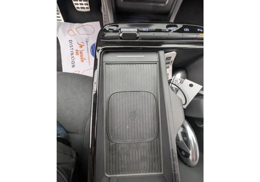 Vue rapprochée de la console centrale noire avec chargeur sans fil et commandes de modes de conduite du Hyundai Tucson gris.