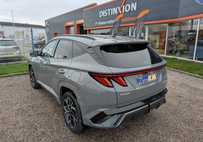 Vue 3/4 arrière droite d’un Hyundai Tucson gris métallisé avec feux arrière LED et jantes alliage 19 pouces N Line.