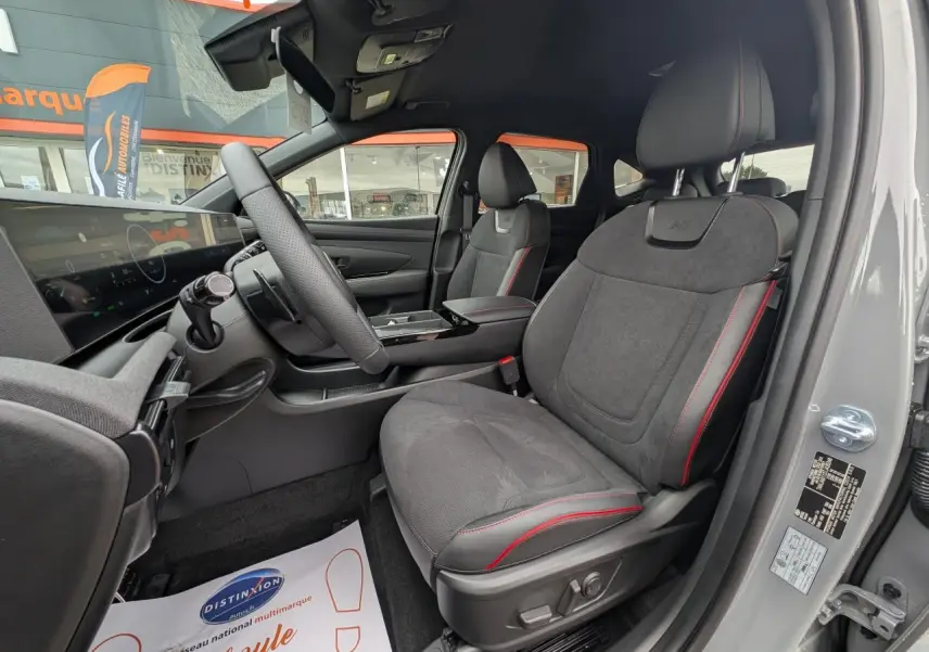 Vue intérieure côté conducteur du Hyundai Tucson gris 2026, sièges N Line en cuir/alcantara avec surpiqûres rouges.