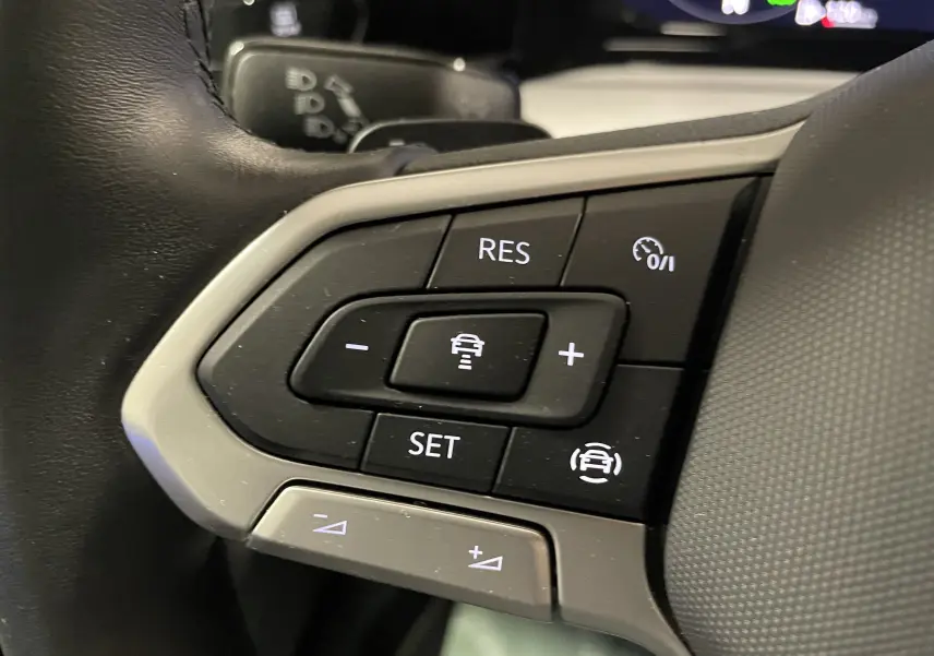 Gros plan sur les commandes de régulateur de vitesse au volant d'une Volkswagen Golf 2023 finition Life Plus.