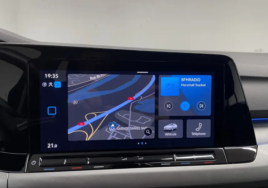 Écran tactile central du tableau de bord de la Volkswagen Golf 2023 affichant navigation et radio.