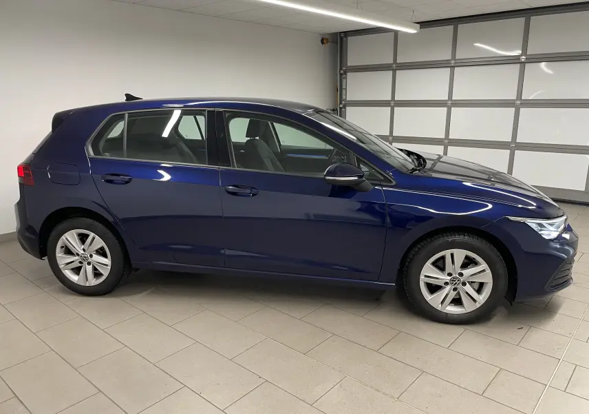 Volkswagen Golf 1.0 TSI 110 DSG7 Life Plus 2023 en bleu Atlantique vue de profil côté gauche dans un garage.