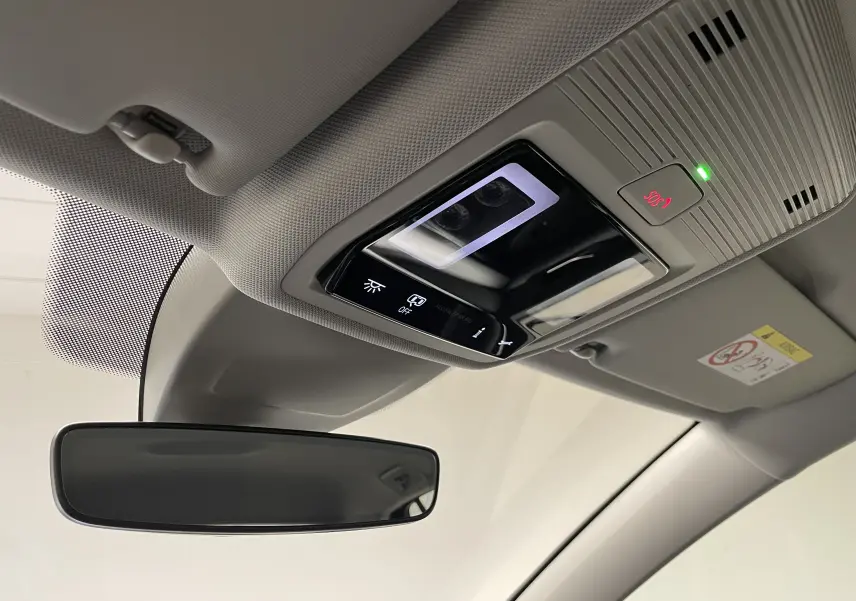 Plafonnier intérieur avec commandes d'éclairage et bouton SOS éclairé, vue depuis le siège conducteur d'une Volkswagen Golf 2023.