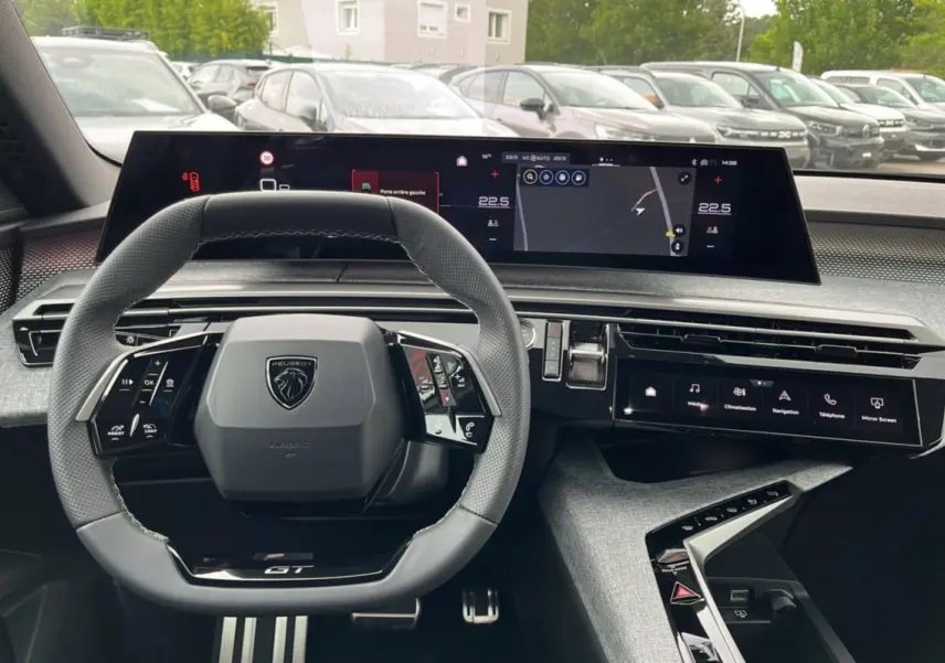Vue intérieure du tableau de bord du Peugeot 5008 Hybrid 145 GT 2025, volant cuir multifonctions et écran digital large.