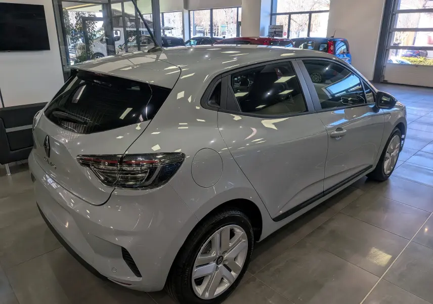 Vue 3/4 arrière droite d'une Renault Clio V gris Rafale en showroom, avec feux arrière LED et jantes alliage.
