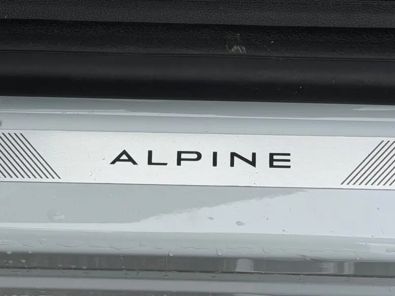 Gros plan sur la plaque de seuil de porte blanche nacrée avec inscription Alpine sur Renault Captur 1.8 E-Tech hybride 2026.