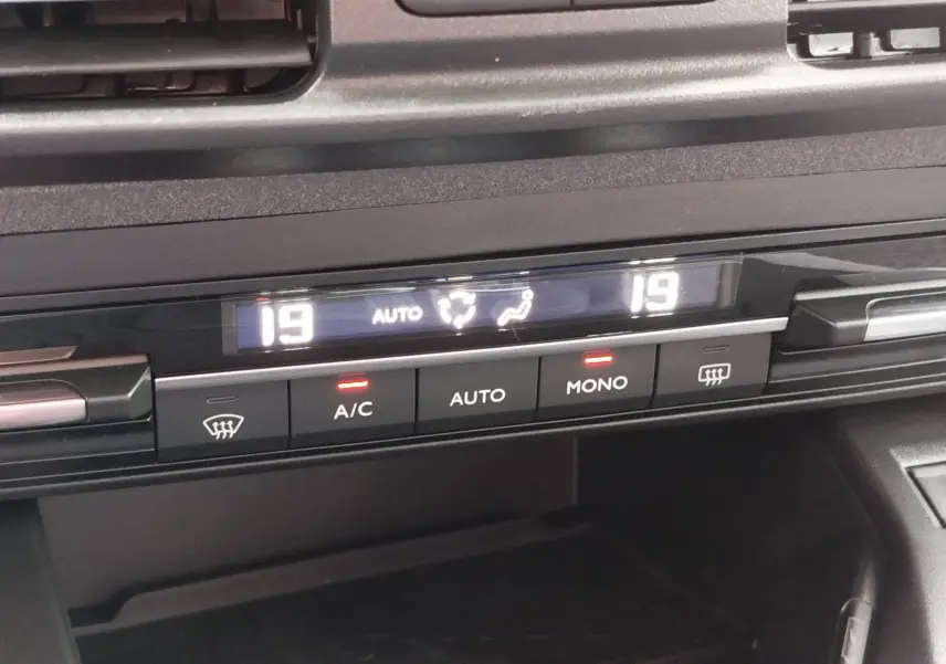 Gros plan sur la commande de climatisation digitale du Peugeot Rifter noir Perla Nera, affichant 19°C en mode auto.