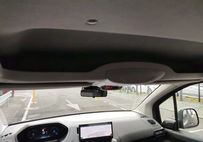 Vue intérieure avant du Peugeot Rifter noir Perla Nera 2026, avec tableau de bord numérique et écran tactile central allumé.