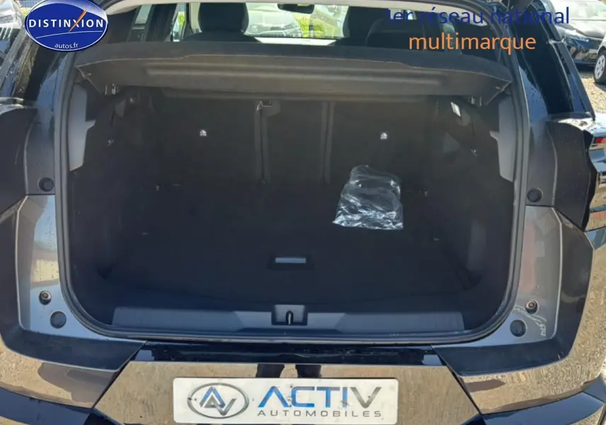 Coffre ouvert vu de l'arrière d'un Citroën C5 Aircross gris platinium avec hayon électrique et plancher de coffre mobile.