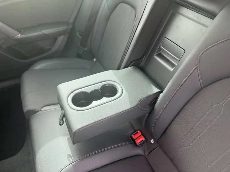 Vue rapprochée de l'accoudoir central arrière avec porte-gobelets sur la banquette textile noire du CUPRA Formentor 2025.