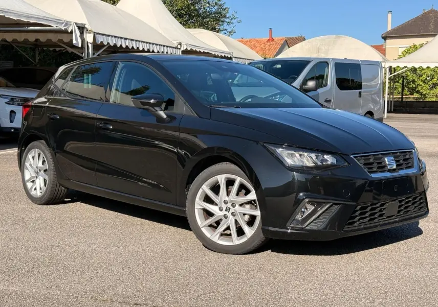 SEAT Ibiza 1.0 TSI 95 FR noire vue en 3/4 avant droit, avec jantes argentées et feux LED allumés.