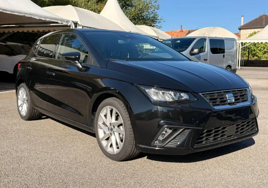 SEAT Ibiza 1.0 TSI 95 FR noire vue en 3/4 avant droit, avec jantes argentées et phares LED allumés.