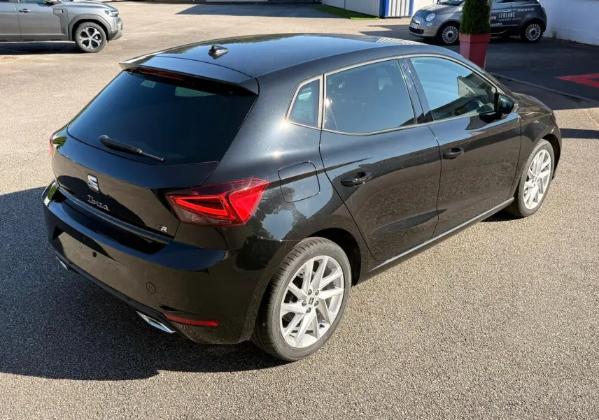 Vue 3/4 arrière droite de la SEAT Ibiza noire 2025 avec jantes alliage et feux arrière LED distinctifs.