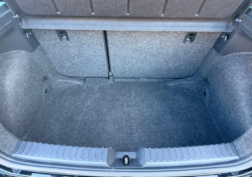 Vue plongeante sur le coffre vide de la SEAT Ibiza noire 2025, montrant la moquette grise et l'ouverture large.
