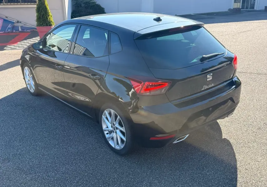 Vue 3/4 arrière droite d'une SEAT Ibiza noire 2025 avec feux arrière LED et jantes alliage argentées.