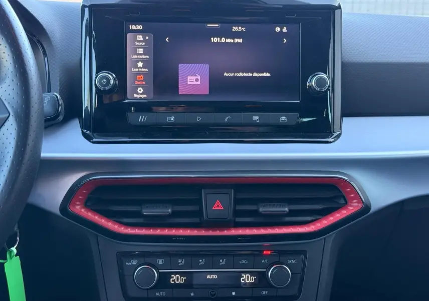 Vue rapprochée du tableau de bord central de la SEAT IBIZA 1.0 TSI 95 FR 2025 avec écran tactile et cadre d’aération rouge.