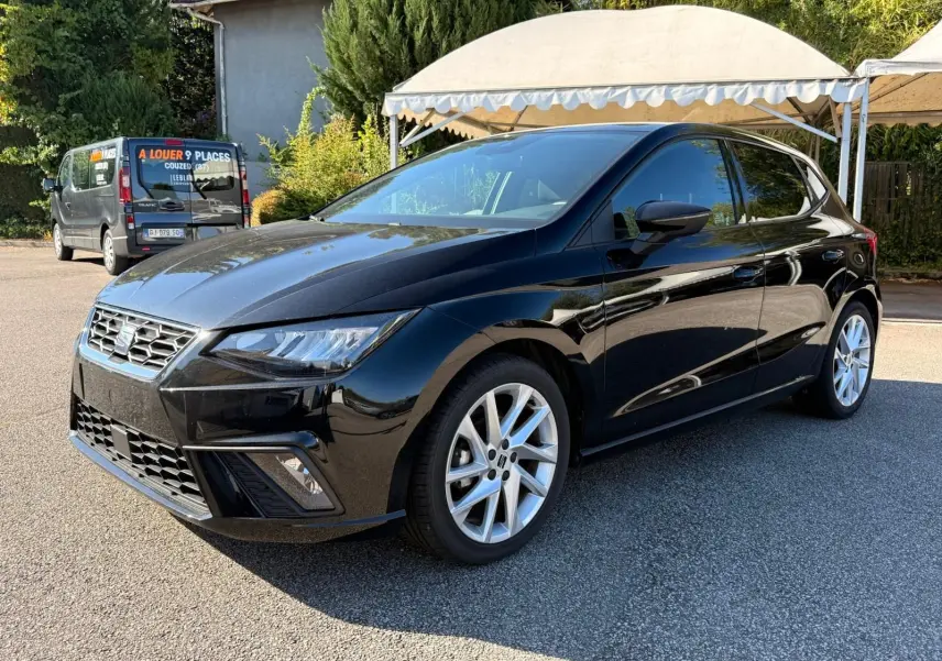 Vue 3/4 avant droite d'une SEAT Ibiza noire 2025 avec jantes alliage et phares LED distinctifs.