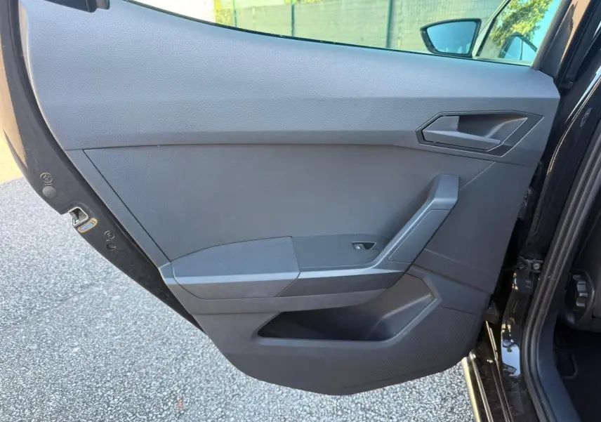 Vue intérieure de la porte arrière droite noire de la SEAT IBIZA 2025 avec poignée et commande de fenêtre intégrée.