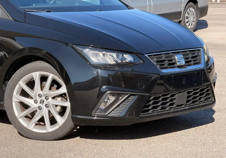 Vue 3/4 avant gauche d'une SEAT Ibiza 2025 noire, avec phares LED et jantes alliage argentées.