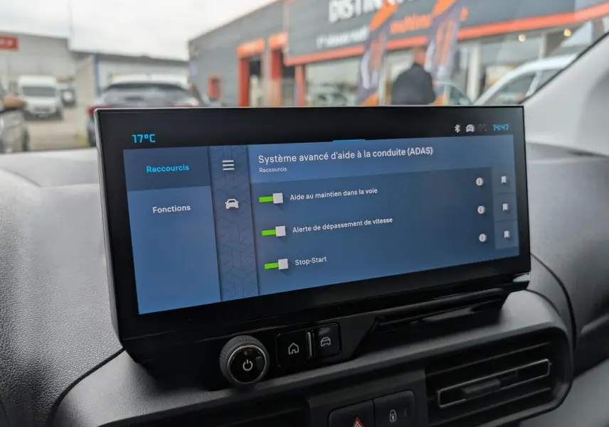 Écran tactile central affichant les aides à la conduite dans l’habitacle du Citroën Berlingo blanc, vue intérieure frontale.