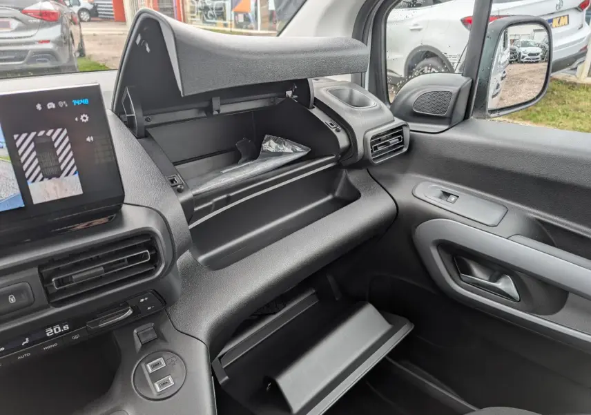 Vue intérieure côté passager du Citroën Berlingo 2025 avec double boîte à gants ouverte et tableau de bord noir.