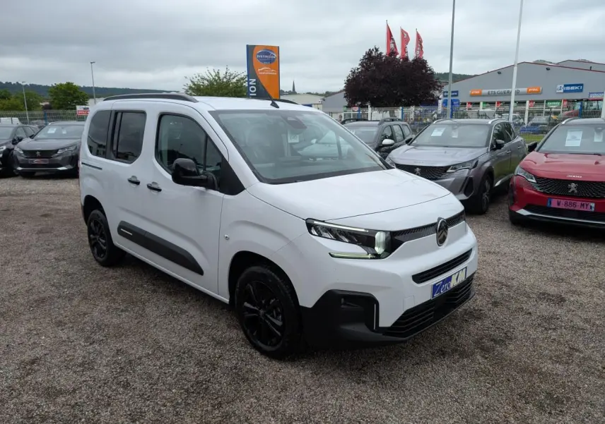 Vue 3/4 avant d'un Citroën Berlingo blanc Kaolin avec barres de toit noires et jantes alliage noires.