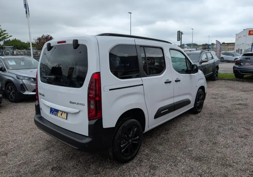 Vue 3/4 arrière droite d'un Citroën Berlingo blanc avec vitres surteintées et jantes alliage noires.