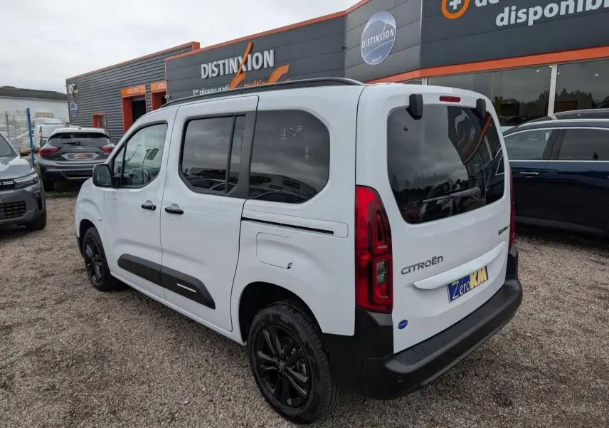 Vue 3/4 arrière droite d'un Citroën Berlingo blanc Kaolin avec jantes alliage noires et vitres surteintées.