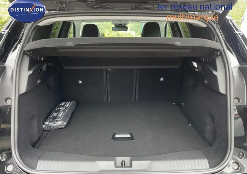 Coffre ouvert vu de l'arrière d'un Citroën C5 Aircross noir Perla Nera, montrant l'espace de chargement vide avec cache-bagages.