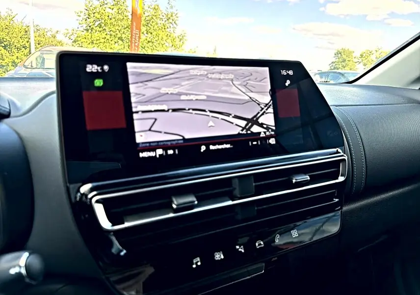 Vue intérieure du tableau de bord du Citroën C5 Aircross 2025, écran tactile GPS et commandes noires brillantes.