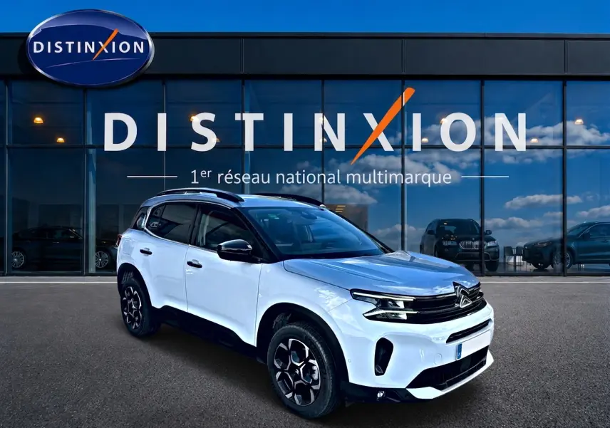 Citroën C5 Aircross blanc vue 3/4 avant droit, avec toit noir et jantes alu noires devant showroom Distinxion.