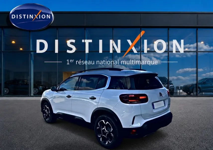 Citroën C5 Aircross blanc vue 3/4 arrière droit avec toit noir et jantes alu noires devant showroom Distinxion.