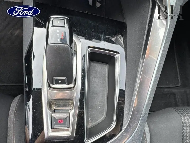 Levier de boîte automatique noir et console centrale brillante d'un Ford, vue de dessus rapprochée.