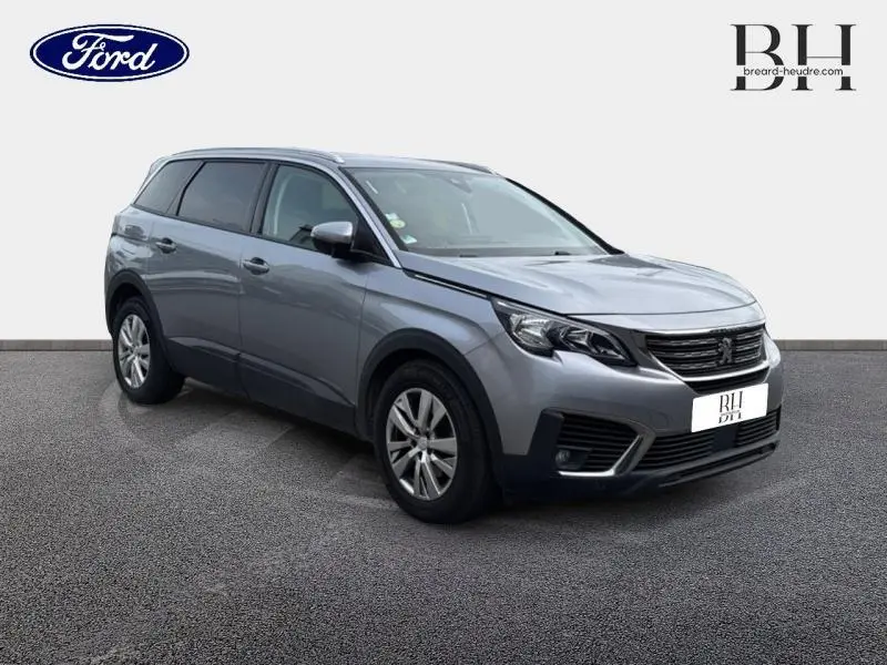 Peugeot 5008 gris Artense en 3/4 avant droit, SUV familial avec jantes alu et vitres surteintées.