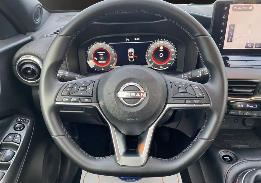 Vue rapprochée du volant noir et du tableau de bord digital du Nissan Juke 2025 avec écran tactile et commandes intégrées.