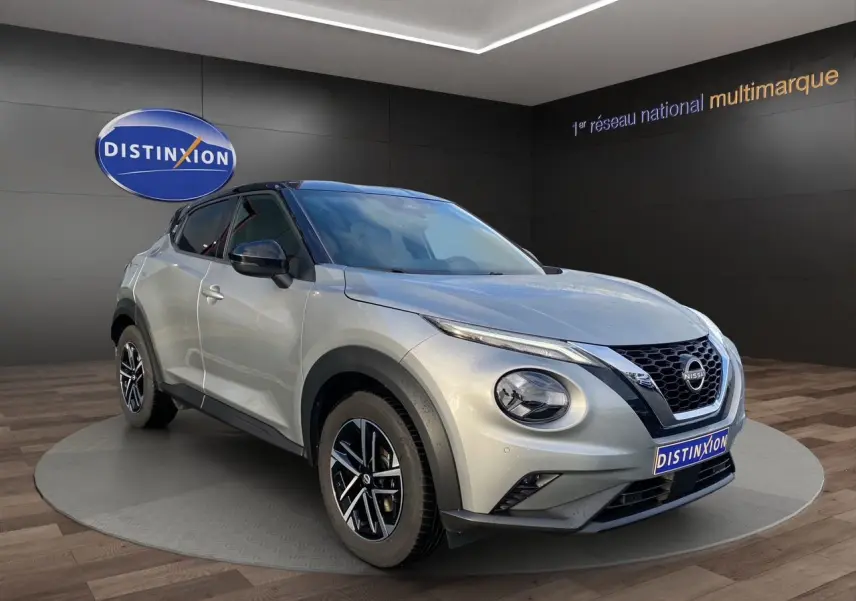 Nissan Juke 2025 gris perle avec toit noir, vue 3/4 avant droit, jantes alliage 17 pouces et calandre distinctive.