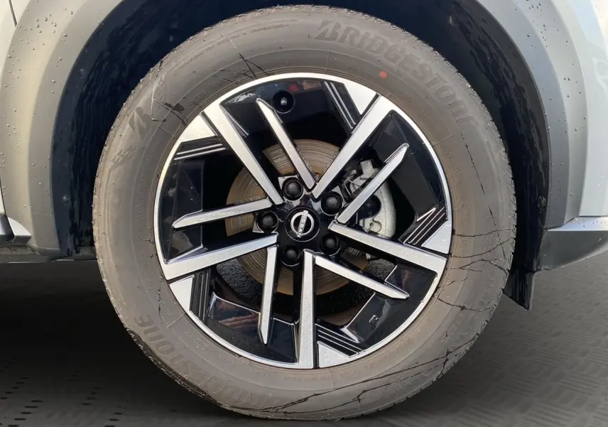 Gros plan sur la jante alliage 17'' noire et argent du Nissan Juke gris perle, côté avant droit.