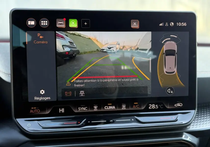 Écran tactile intérieur affichant la caméra de recul et l’aide au stationnement du CUPRA Leon blanc Neige.