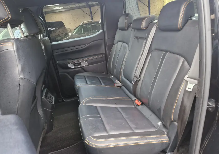 Vue intérieure côté droit des sièges arrière en cuir noir avec surpiqûres orange du Ford Ranger Double Cabine 2023.