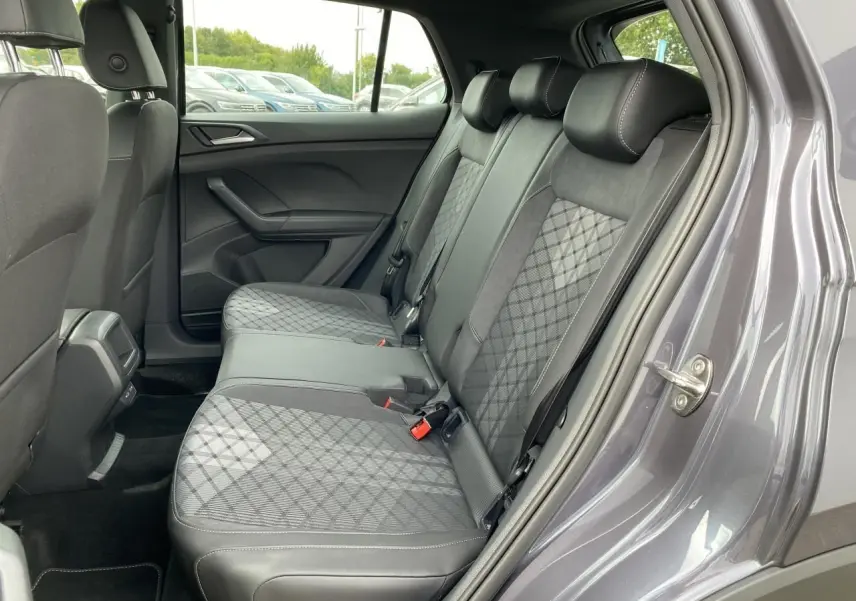 Vue côté droit de la banquette arrière grise à motifs géométriques du Volkswagen T-Cross 2024 avec porte ouverte.