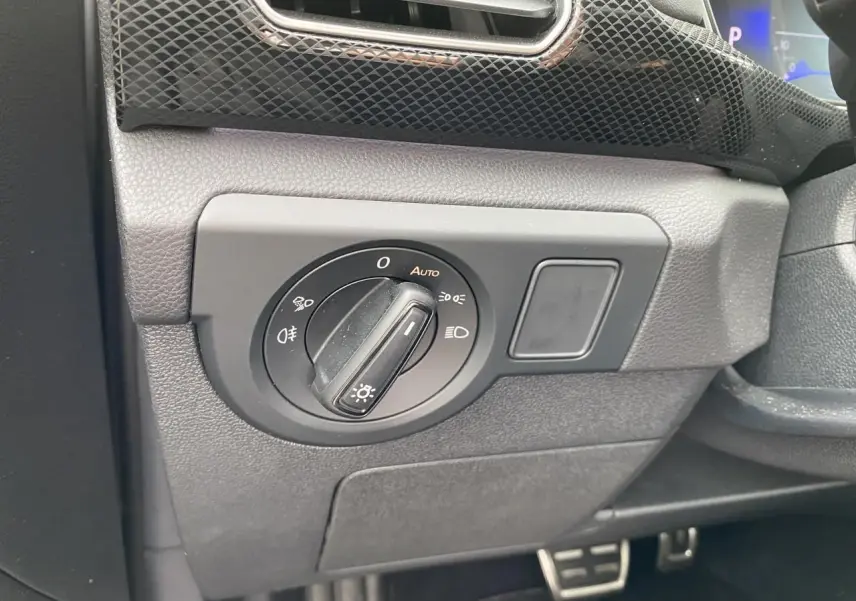Gros plan sur le bouton de commande des phares dans l’habitacle gris du Volkswagen T-Cross 2024 côté gauche.