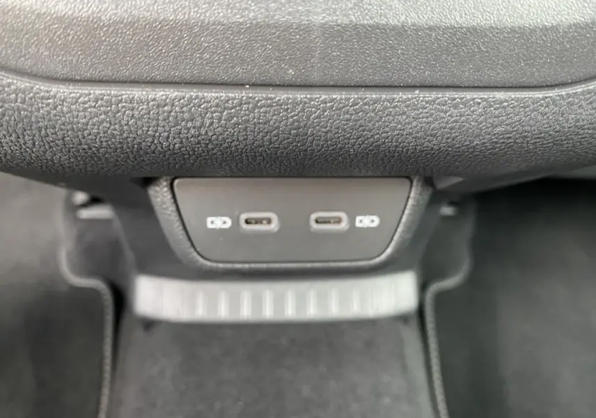 Vue rapprochée des deux ports USB-C situés sous la planche de bord du Volkswagen T-Cross gris.