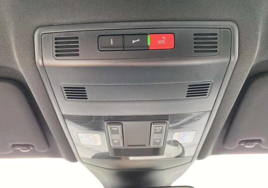 Vue intérieure du plafonnier gris foncé du Volkswagen T-Cross 2024 avec boutons SOS et éclairage intégré.