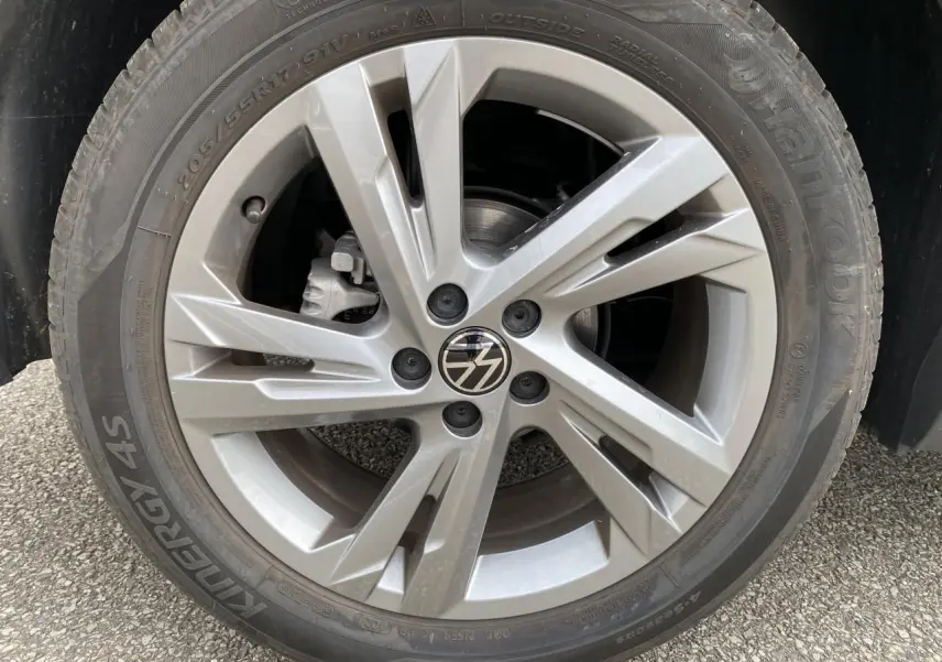 Gros plan sur la roue avant droite grise du Volkswagen T-Cross 2024 avec jante alliage à cinq branches doubles.