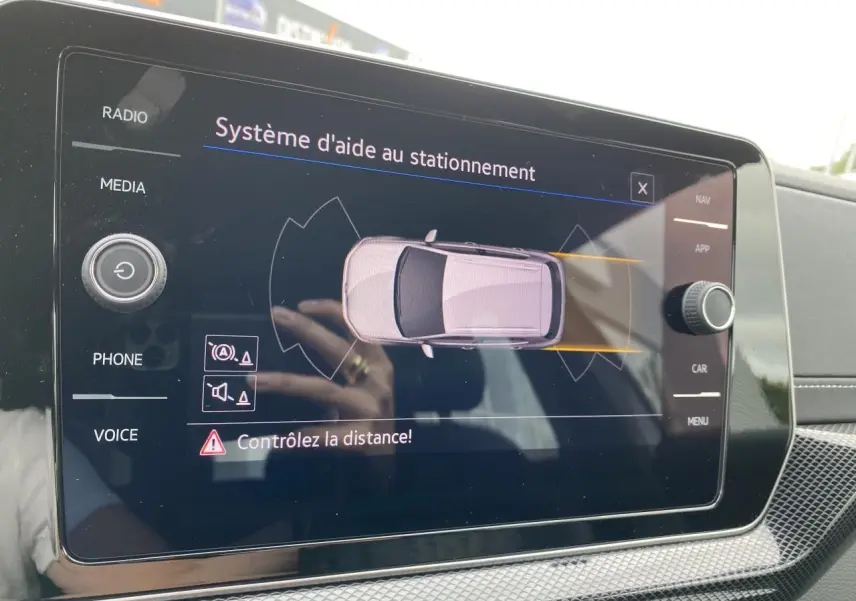 Écran tactile intérieur du Volkswagen T-Cross gris montrant le système d'aide au stationnement.