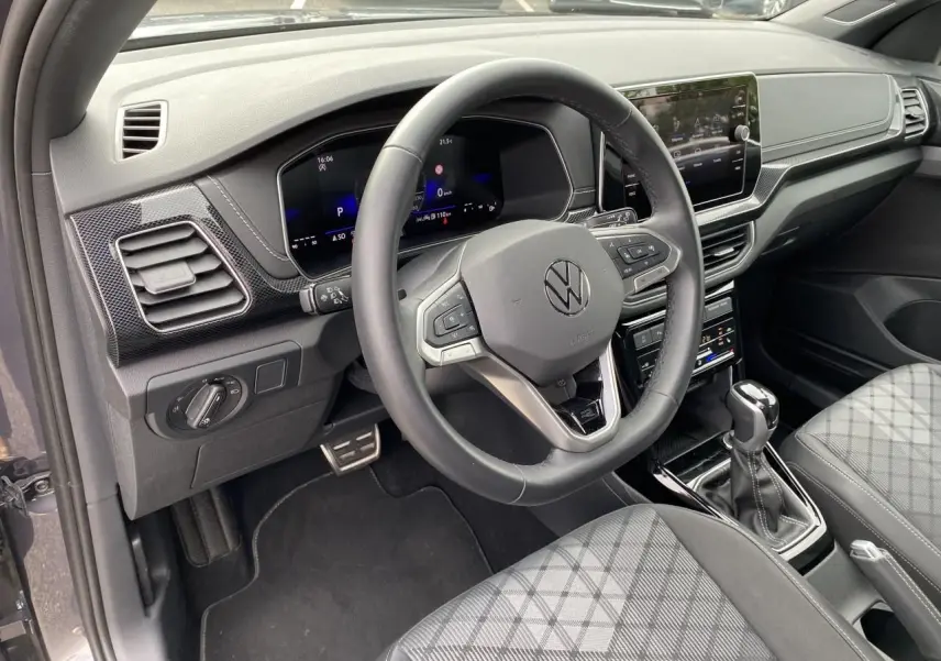 Vue intérieure côté conducteur du Volkswagen T-Cross gris 2024, volant cuir multifonction et tableau de bord digital.