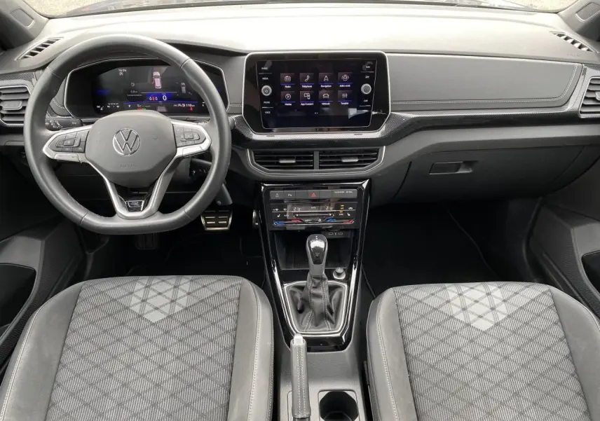 Vue intérieure frontale du Volkswagen T-Cross gris 2024, avec tableau de bord digital et volant multifonction cuir.