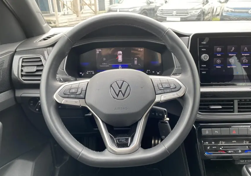 Vue intérieure centrée sur le volant cuir multifonction du Volkswagen T-Cross 2024 avec tableau de bord digital.