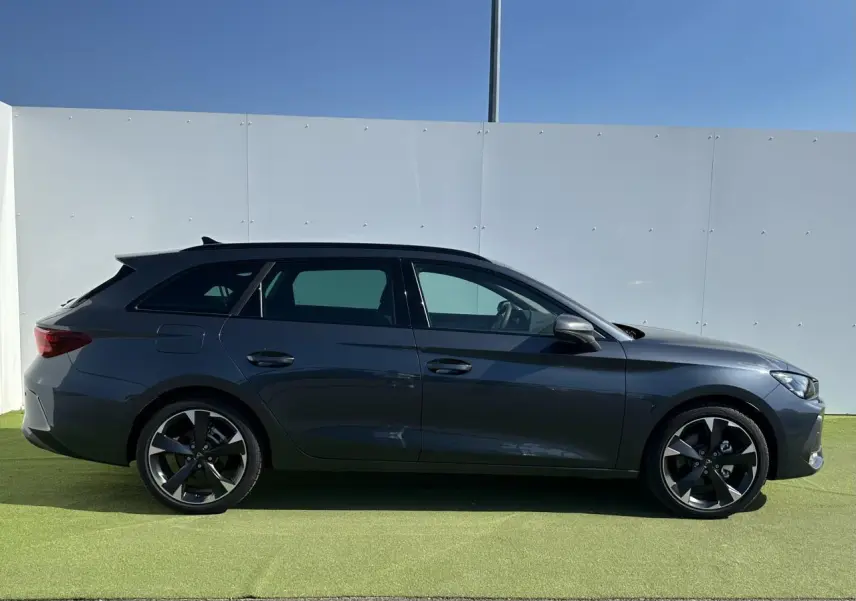 Profil côté gauche d'une CUPRA Leon Sportstourer 2025 gris magnétique avec jantes alliage noires et toit noir.